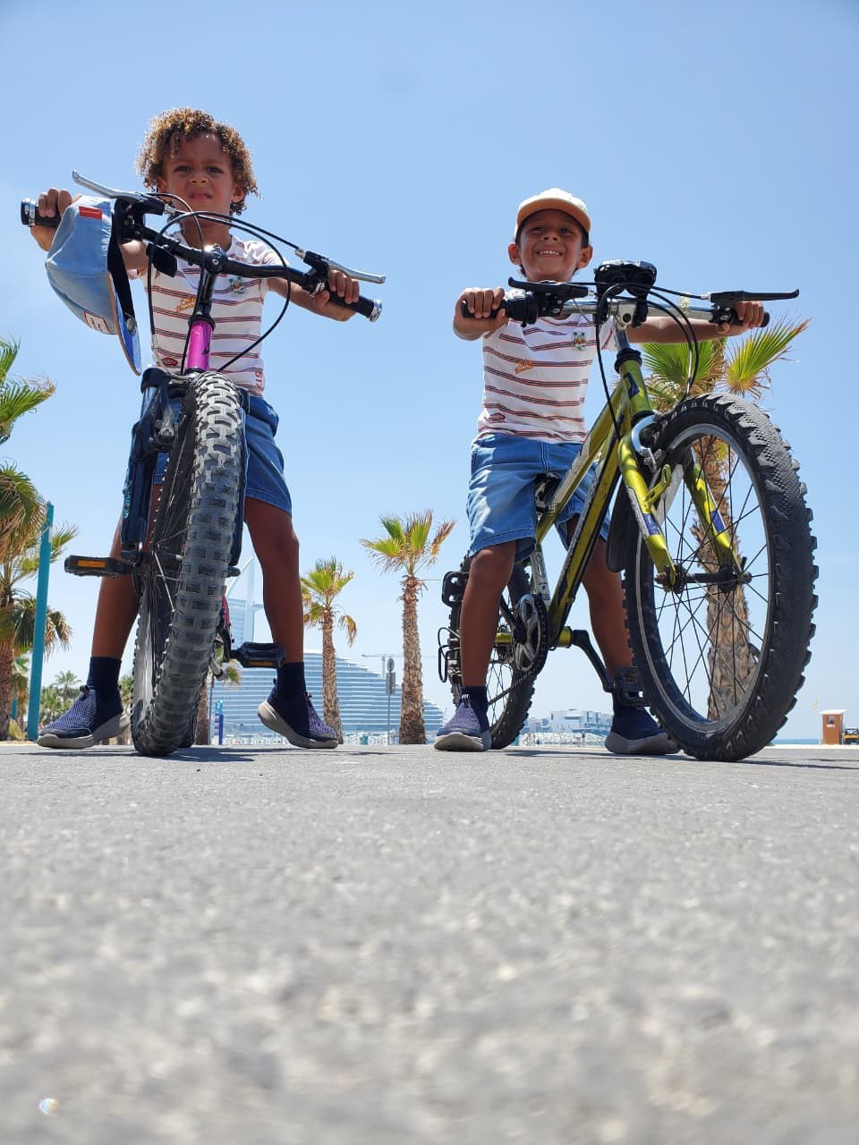Two young riders standing with their bikes lifted beside them
