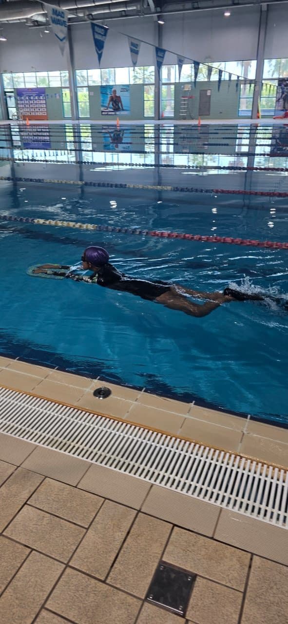 Swimmer moving through a marked lane in an indoor pool